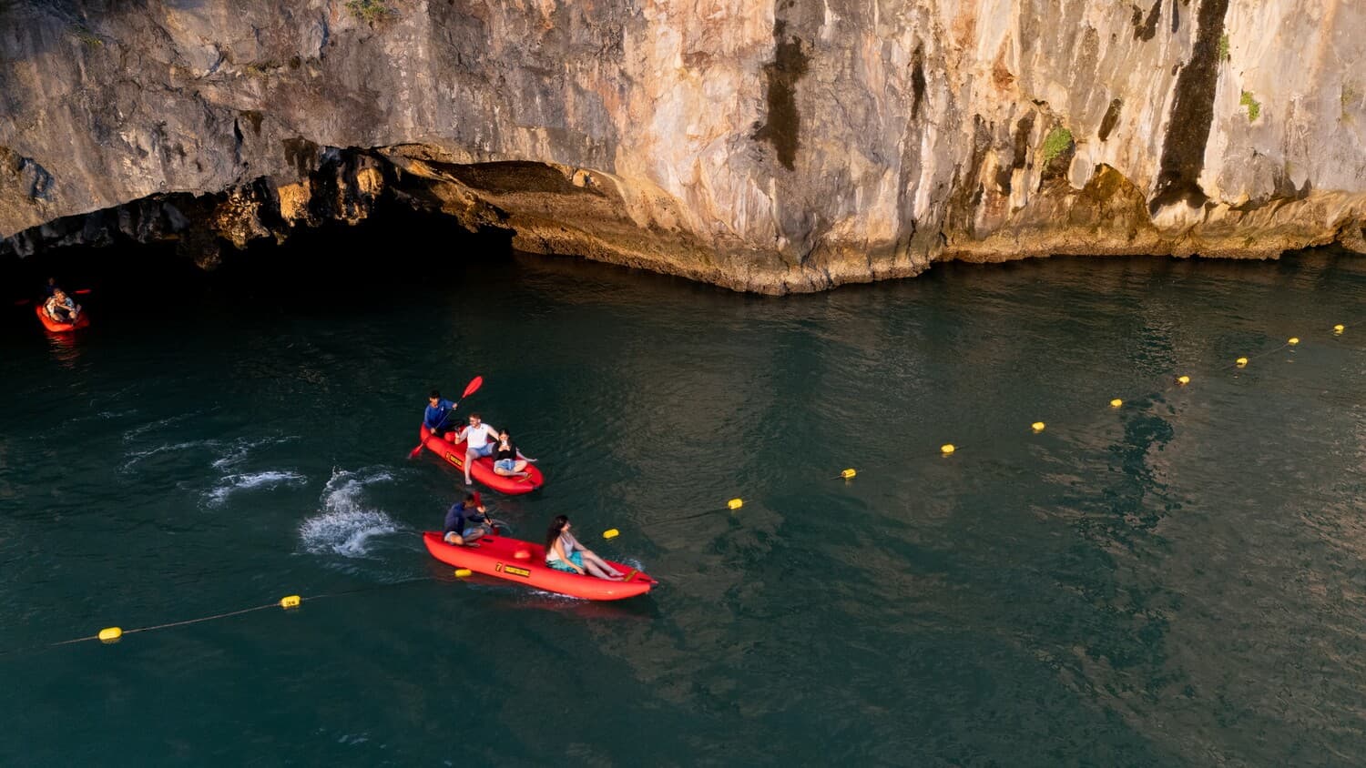 Guests swimming and canoeing beside the limestone cliffs